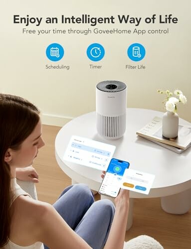 Woman using app to control smart air purifier on table.